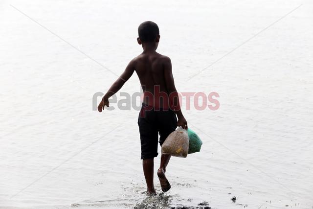 Sri Lankan boy carry rations during flood times